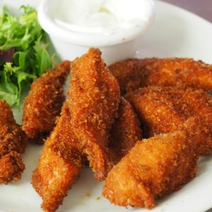 Delicious crispy fried chicken tenders served with a fresh green salad and dipping sauce.